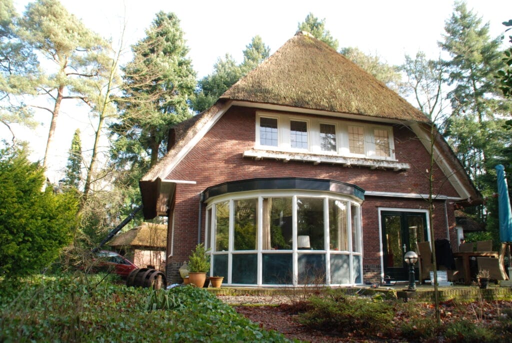 Villa in bosrijke omgeving met een rieten dak volledig geschilderd.